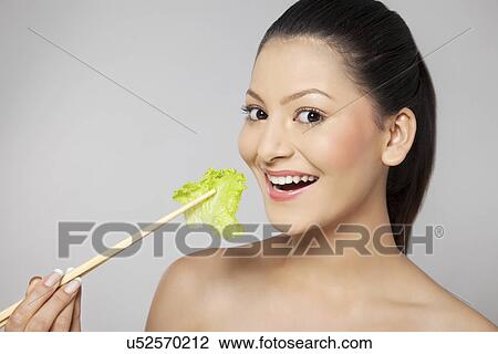 Close-up portrait of woman eating lettuce View Large Photo Image Stock Image - Close-up portrait of woman eating lettuce . Fotosearch