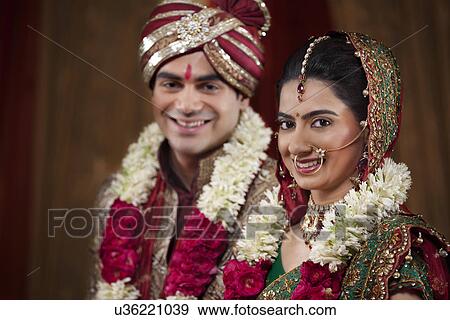 Close-up portrait of young couple wearing garlands View Large Photo Image Stock Photo - Close-up portrait of young couple wearing garlands . Fotosearch