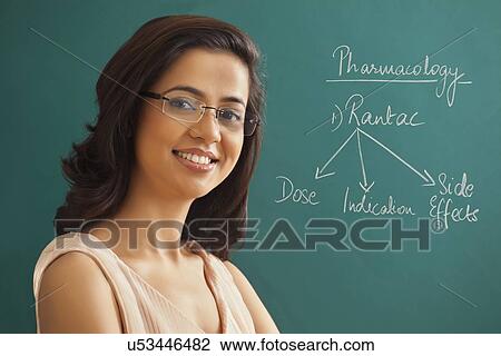 Close-up portrait of young female teacher against green board View Large Photo Image Stock Image - Close-up portrait of young female teacher against green board . Fotosearch
