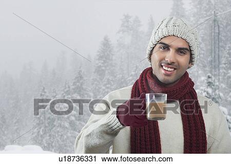 Close-up portrait of young man holding tea cup in winter View Large Photo Image Stock Image - Close-up portrait of young man holding tea cup in winter . Fotosearch