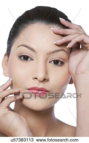 Close-up portrait of young woman touching her face View Large Photo Image Stock Image - Close-up portrait of young woman touching her face . Fotosearch