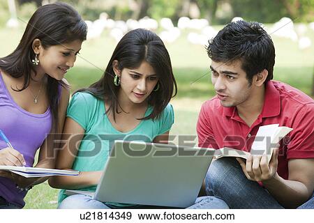Stock Photo - College friends sitting in lawn . Fotosearch