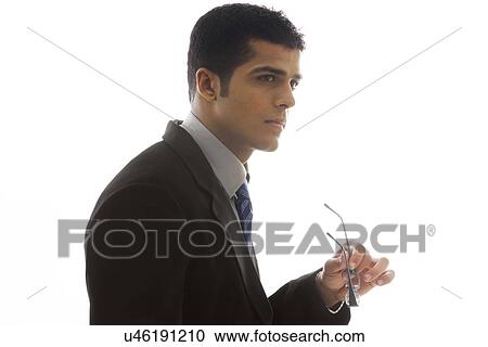 Confident business man holding glasses over white background View Large Photo Image Stock Image - Confident business man holding glasses over white background . Fotosearch