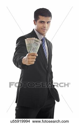 Confident businessman holding Indian currency over white background View Large Photo Image Picture - Confident businessman holding Indian currency over white background . Fotosearch