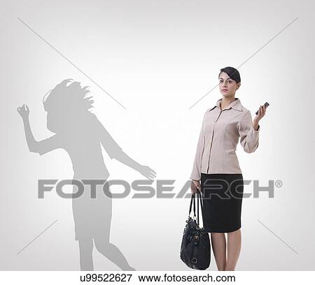 Confident businesswoman standing against shadow dancing over gray background View Large Photo Image Stock Photo - Confident businesswoman standing against shadow dancing over gray background. Fotosearch