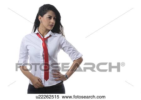 Stock Photography - Confident fashionable businesswoman with hand on hip against white background. Fotosearch