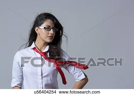 Picture - Confident stylish businesswoman with windswept tie against gray background. Fotosearch