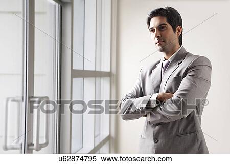 Confident young business man lost in thoughts View Large Photo Image Stock Photography - Confident young business man lost in thoughts . Fotosearch