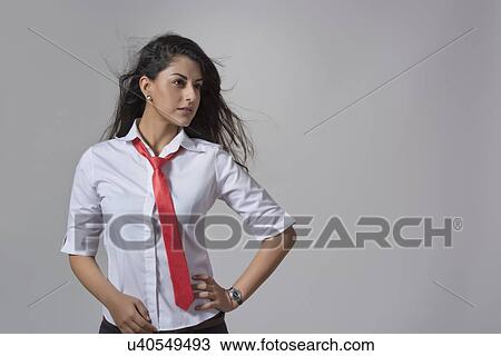 Confident young fashionable businesswoman with hand on hip standing against gray background View Large Photo Image Stock Image - Confident young fashionable businesswoman with hand on hip standing against gray background. Fotosearch