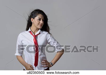 Confident young fashionable businesswoman smiling against gray background View Large Photo Image Stock Image - Confident young fashionable businesswoman smiling against gray background. Fotosearch