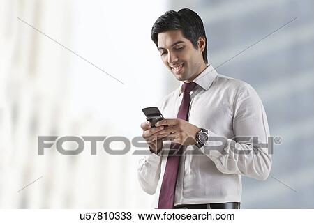 Confident young man text messaging on white background View Large Photo Image Stock Image - Confident young man text messaging on white background . Fotosearch