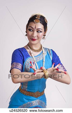 Confident young woman performing classical dance on gray background View Large Photo Image Stock Image - Confident young woman performing classical dance on gray background. Fotosearch