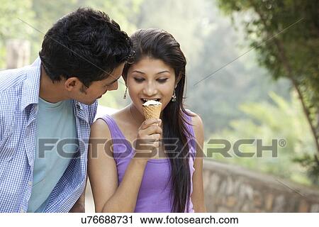 Couple eating ice cream in lawn View Large Photo Image Stock Image - Couple eating ice cream in lawn . Fotosearch