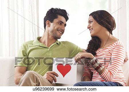 Stock Photo - Couple holding a placard with a drawn heart. Fotosearch