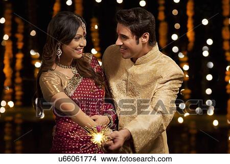 Couple holding a sparkler View Large Photo Image Picture - Couple holding a sparkler. Fotosearch