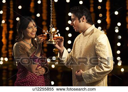 Stock Photography - Couple holding diyas. Fotosearch