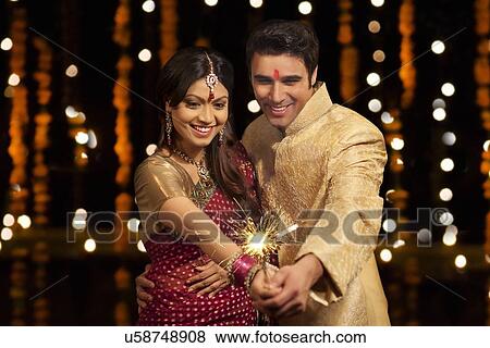 Couple holding sparkler View Large Photo Image Stock Photo - Couple holding sparkler. Fotosearch