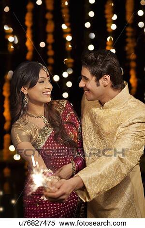 Stock Photography - Couple holding sparkler. Fotosearch