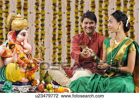 Stock Image - Couple performing a pooja . Fotosearch