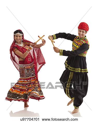 Stock Image - Couple performing dandia dance . Fotosearch