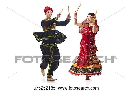 Couple performing dandia dance View Large Photo Image Stock Photography - Couple performing dandia dance . Fotosearch