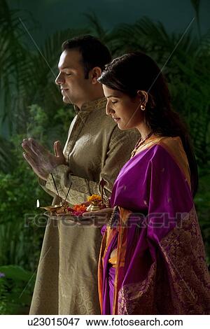 Couple praying during diwali View Large Photo Image Stock Photo - Couple praying during diwali . Fotosearch