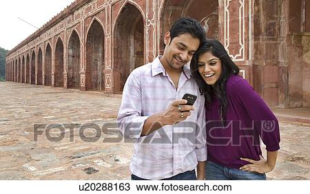 Couple reading an sms at Humayuns Tomb View Large Photo Image Stock Image - Couple reading an sms at Humayuns Tomb . Fotosearch