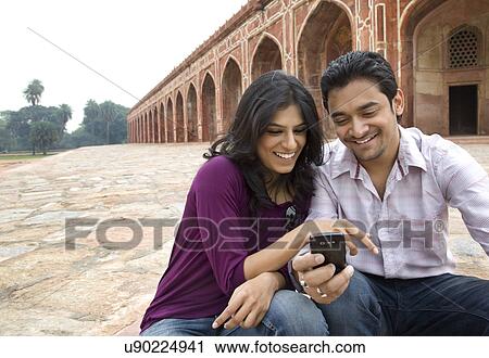 Couple reading an sms at Humayuns Tomb View Large Photo Image Stock Image - Couple reading an sms at Humayuns Tomb . Fotosearch
