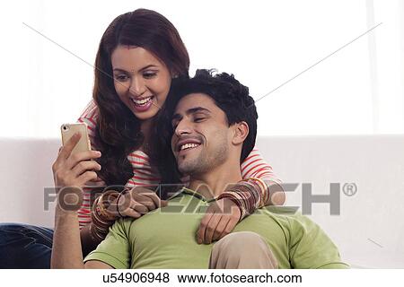 Stock Photo - Couple reading an sms on a mobile phone. Fotosearch
