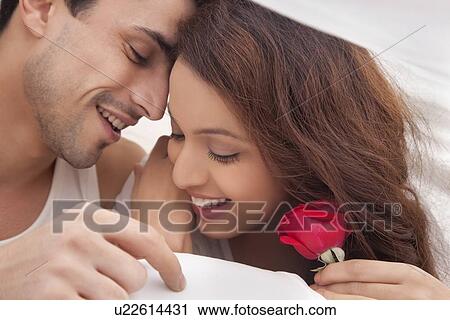 Couple romancing in bed View Large Photo Image Stock Image - Couple romancing in bed. Fotosearch