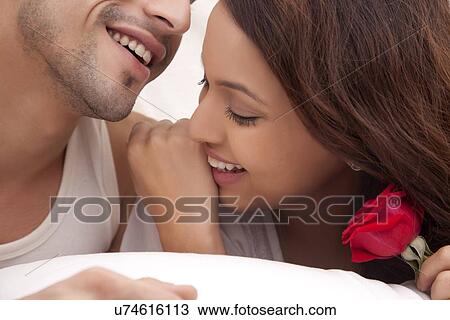 Stock Image - Couple romancing in bed. Fotosearch