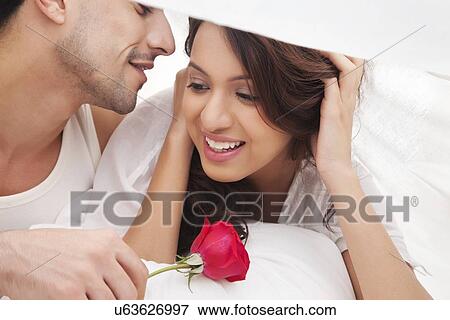 Couple romancing in bed View Large Photo Image Stock Photo - Couple romancing in bed. Fotosearch