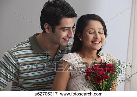 Couple spending affectionate time together with a bouquet View Large Photo Image Stock Photo - Couple spending affectionate time together with a bouquet . Fotosearch