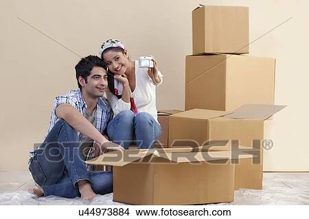Picture - Couple taking self portrait with digital camera at new home . Fotosearch