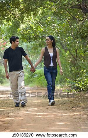 Couple walking in a park View Large Photo Image Stock Image - Couple walking in a park . Fotosearch
