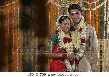 Stock Photo - Couple wearing garlands during traditional Indian wedding . Fotosearch