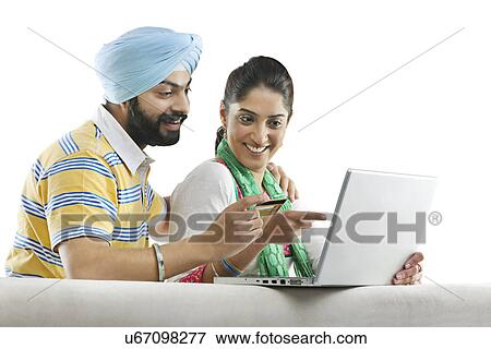 Stock Photo - Couple with a laptop and credit card . Fotosearch