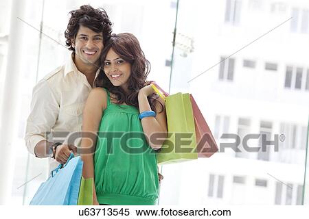 Stock Photography - Couple with shopping bags at a mall . Fotosearch