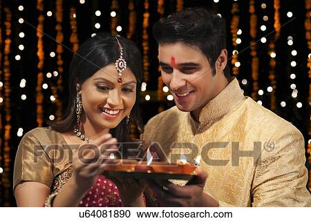 Stock Image - Couple with tray of diyas. Fotosearch