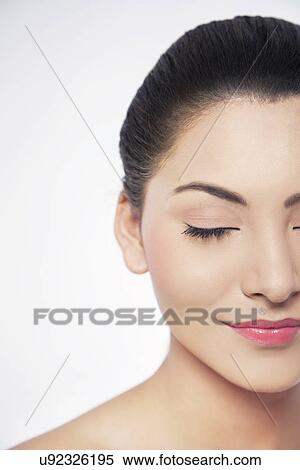 Stock Photography - Cropped image of a smiling young woman with eyes closed . Fotosearch