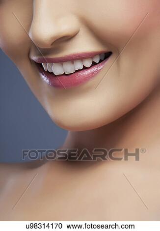 Cropped image of a young woman's beautiful smile over colored background View Large Photo Image Stock Image - Cropped image of a young woman's beautiful smile over colored background . Fotosearch