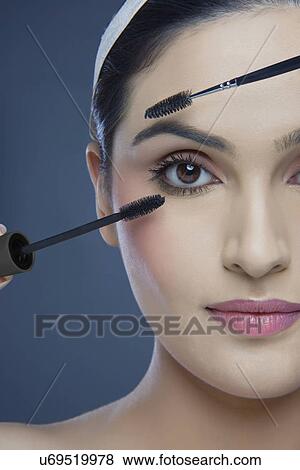 Cropped image of an attractive young woman with mascara and eyebrow tinting applicator over colored background View Large Photo Image Stock Photo - Cropped image of an attractive young woman with mascara and eyebrow tinting applicator over colored background . Fotosearch