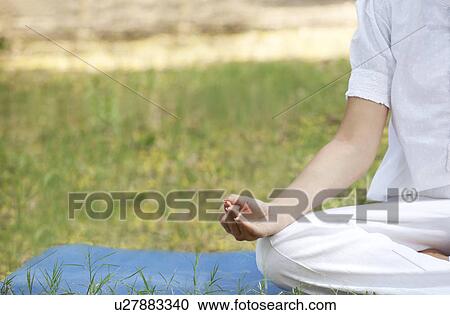 Stock Image - Cropped image of woman practicing yoga . Fotosearch
