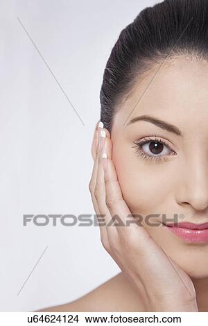 Picture - Cropped image of young woman touching her cheeks . Fotosearch