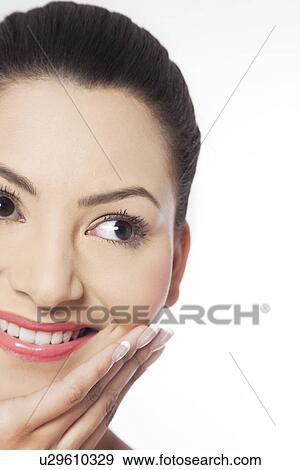 Cropped image of young woman with hand on chin View Large Photo Image Stock Photo - Cropped image of young woman with hand on chin . Fotosearch