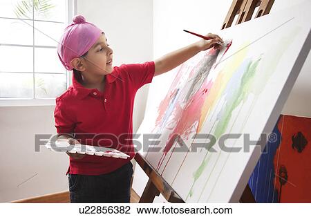 Stock Image - Cute little boy painting on artist's canvas . Fotosearch