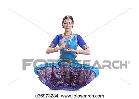 Picture - Dancer gesturing while performing Bharatanatyam against white background. Fotosearch