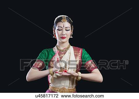 Dancer with eyes closed performing Bharatanatyam against black background View Large Photo Image Stock Image - Dancer with eyes closed performing Bharatanatyam against black background. Fotosearch
