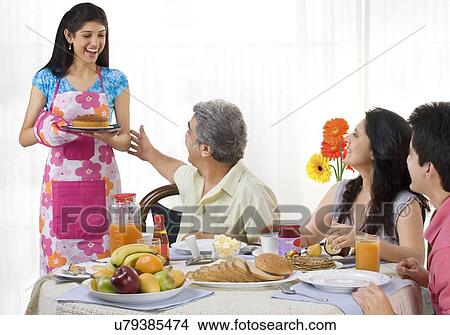 Daughter serving her family View Large Photo Image Picture - Daughter serving her family . Fotosearch