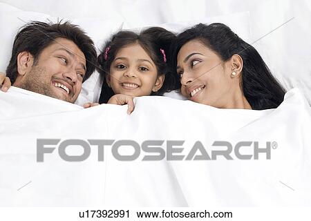 Stock Image - Daughter sleeping with her parents . Fotosearch